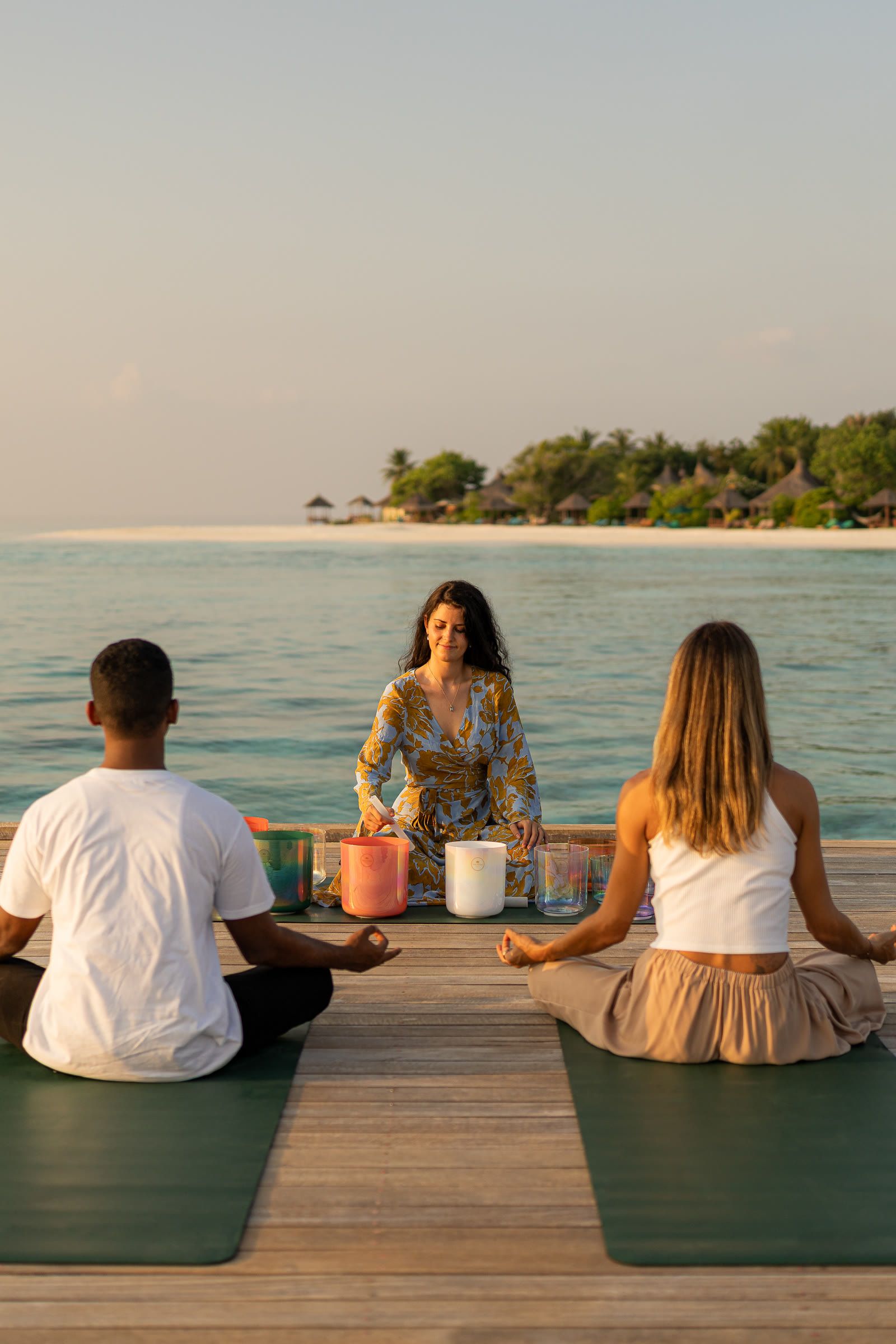 Harriet Emily leading a sound meditation on a jetty at Banyan Tree Vabbinfaru, Maldives