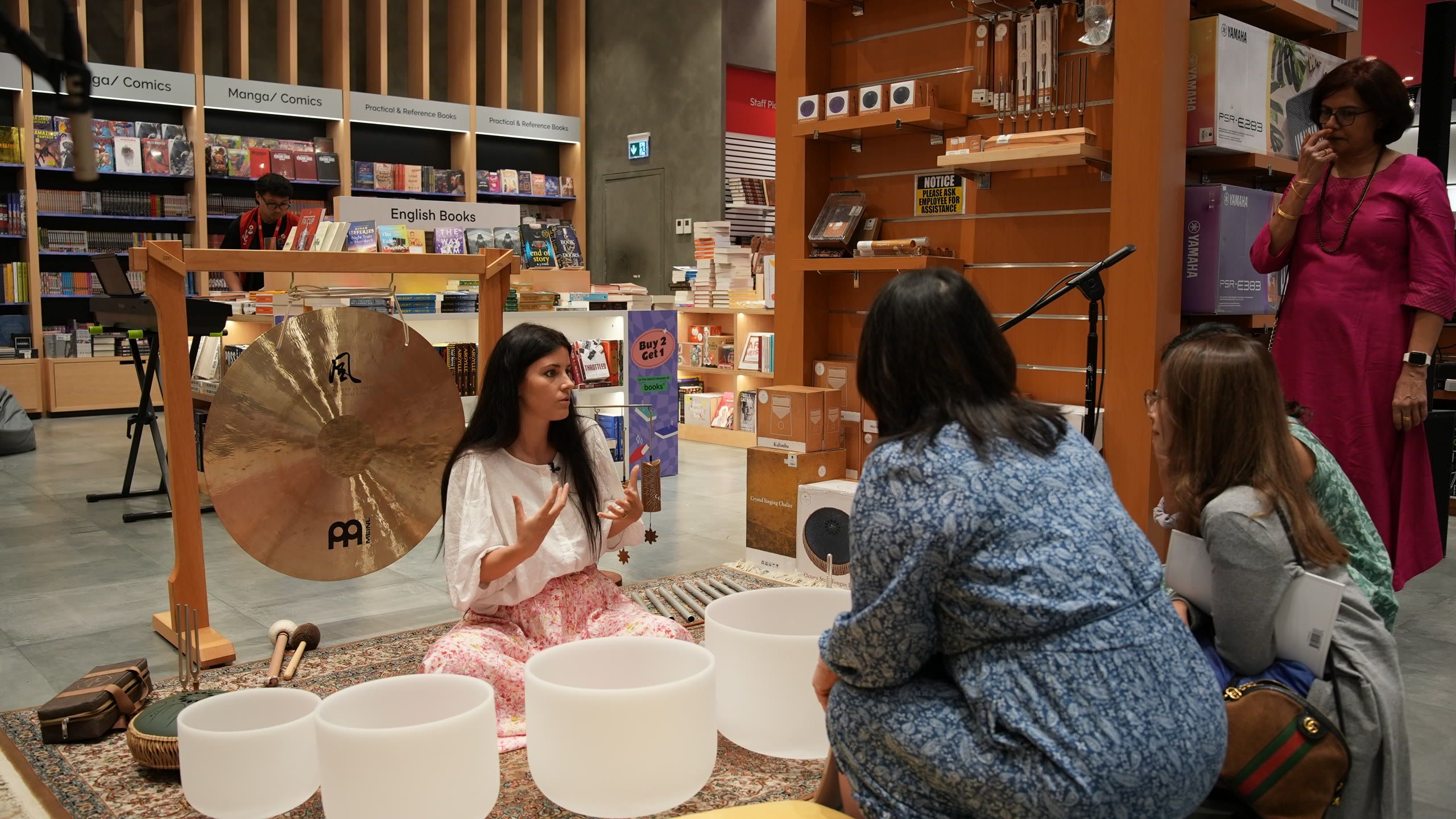Harriet Emily leading a gong and crystal bowl workshop for guests in a bookshop