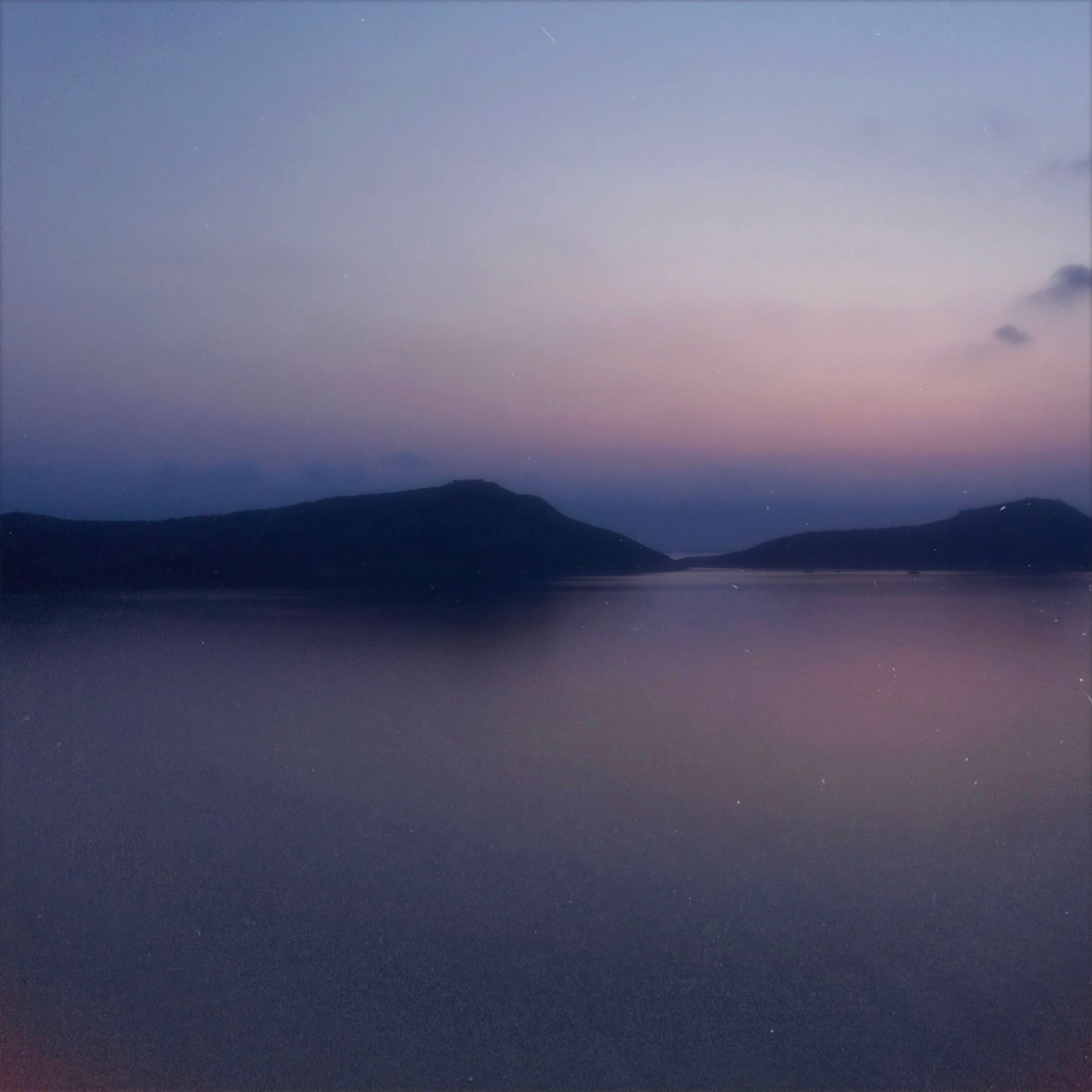 Islands at dusk across still water